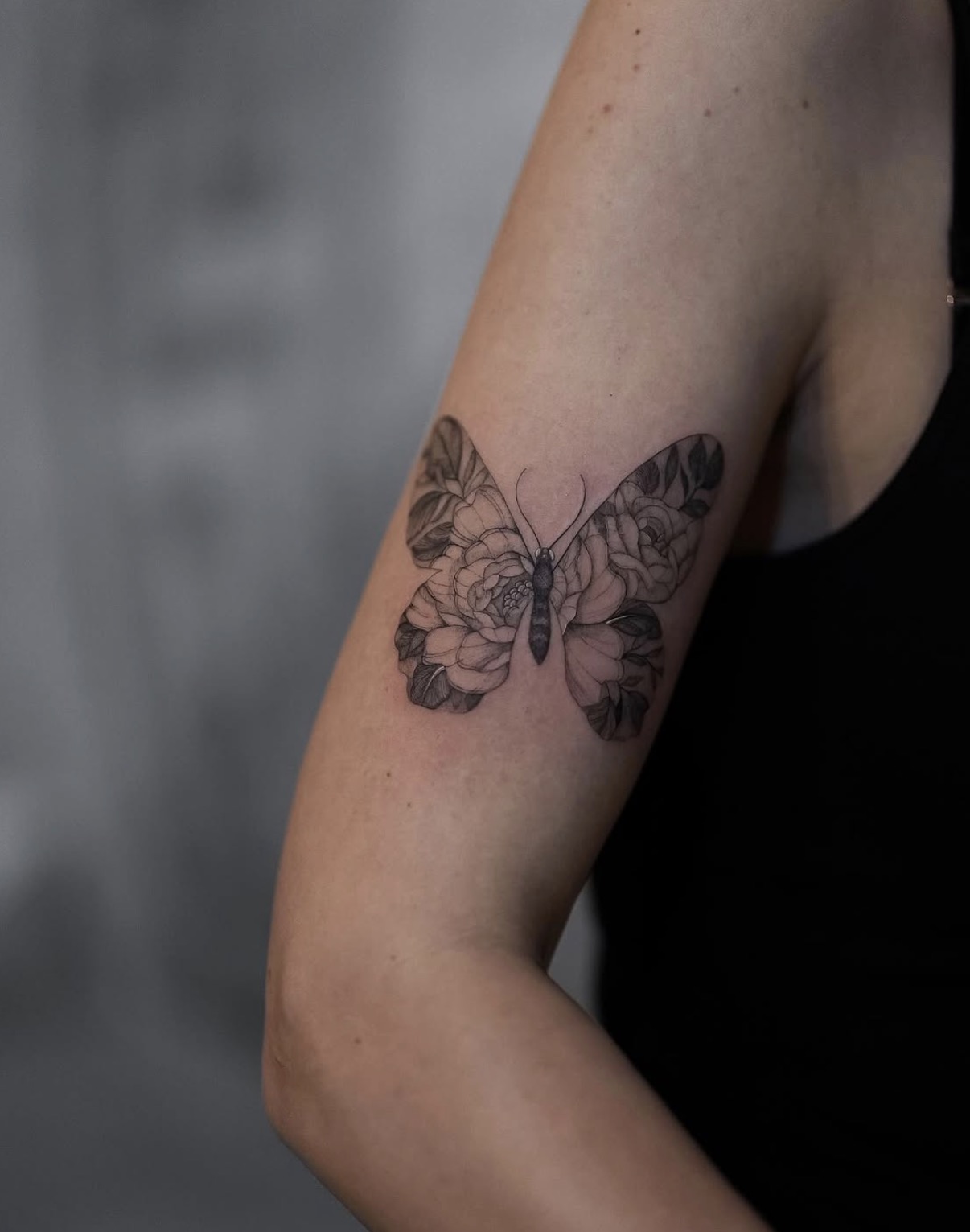 Schmetterling mit Blüten am Oberarm